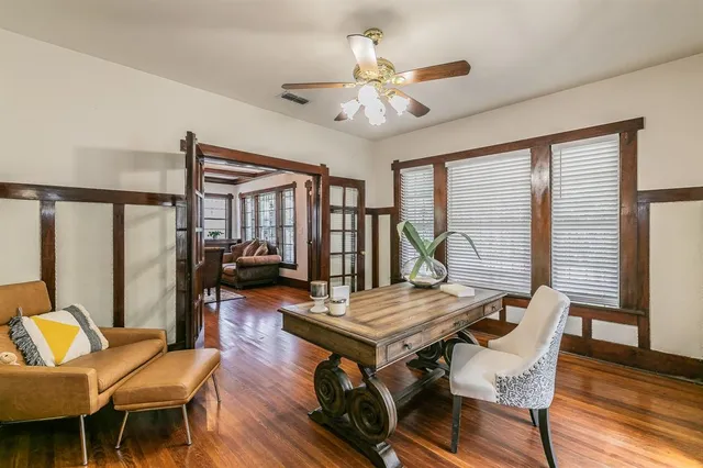 a living room with furniture a ceiling fan and a large window