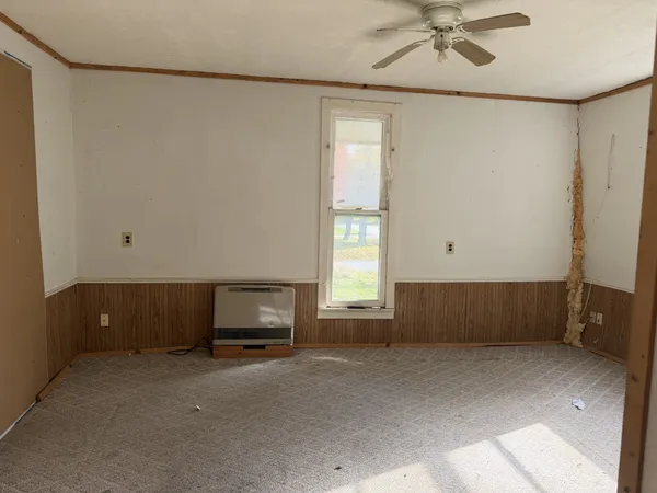 a living room with a bed and a window