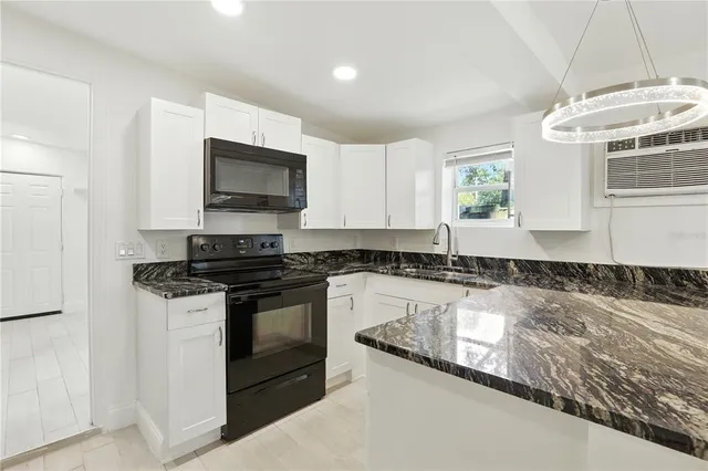 a kitchen with granite countertop a stove and a sink