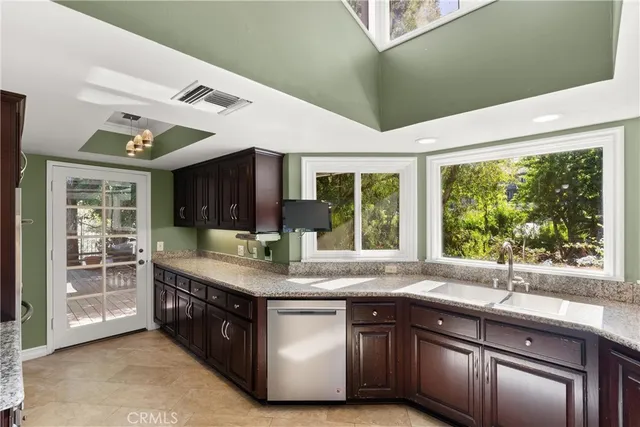 a kitchen with stainless steel appliances granite countertop a sink and a large window