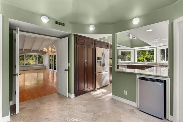 a view of kitchen with refrigerator and window