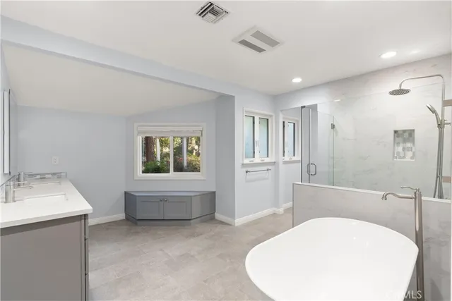 a bathroom with a sink a bathtub and a window