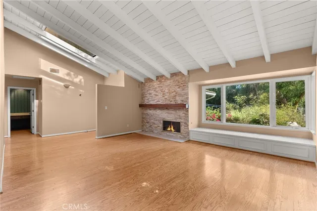 a view of an empty room with a fireplace and a window