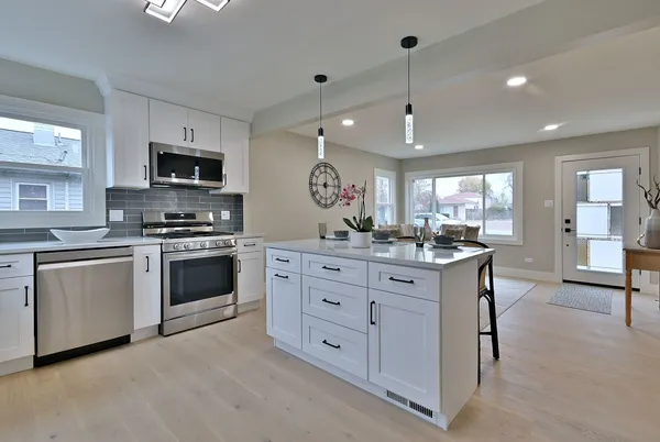 a kitchen with white cabinets and stainless steel appliances