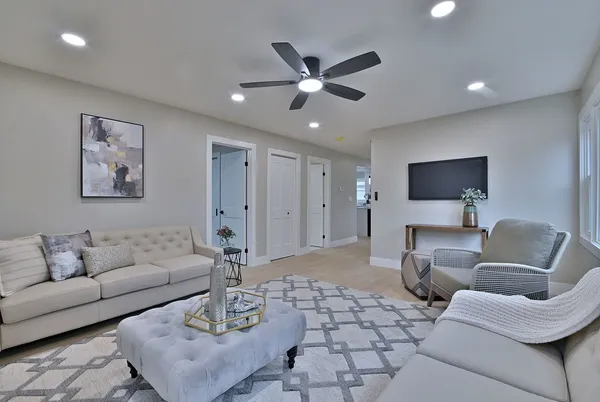a living room with furniture and a ceiling fan