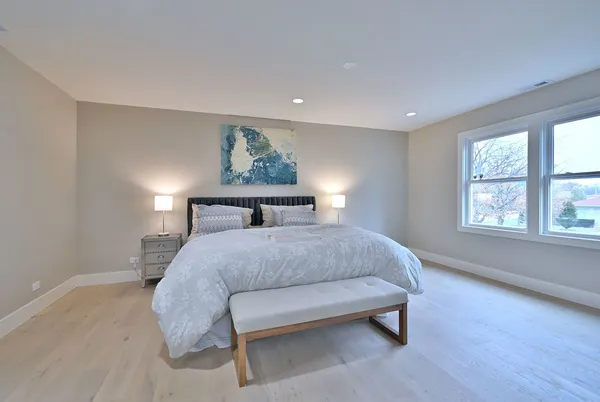 a spacious bedroom with a bed and a window