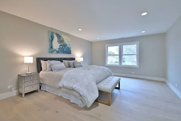 a spacious bedroom with a bed and a lamp