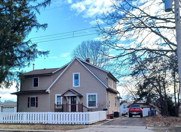a view of a house with a cars park side of a road