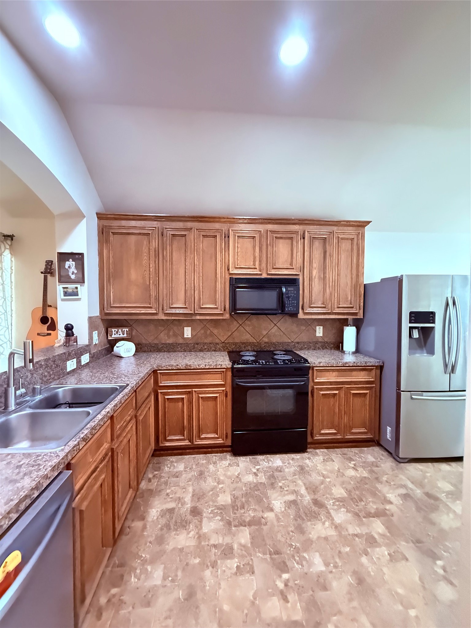 2327 Kylie Court Spring, TX 77386 - Photo 3 of 15 a large kitchen with kitchen island granite countertop a stove top oven a sink a counter space and cabinets