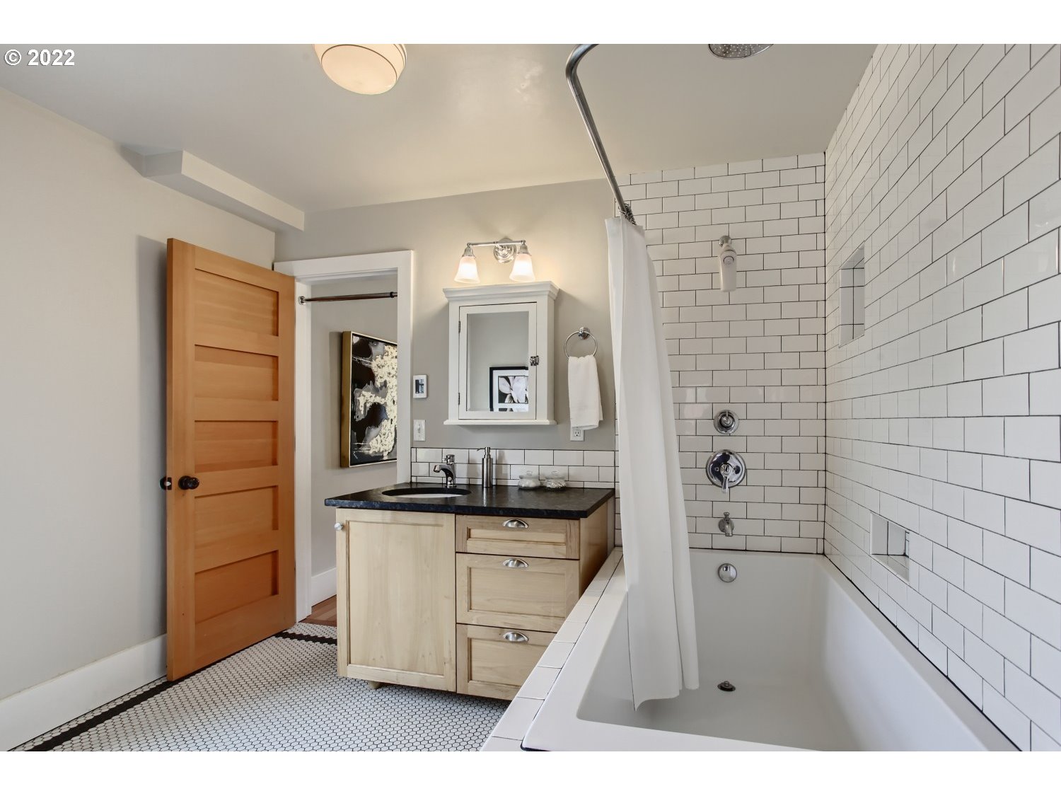 4347 Northeast Sumner Street Portland, OR 97218 - Photo 12 of 25 a bathroom with a sink a mirror and a bathtub