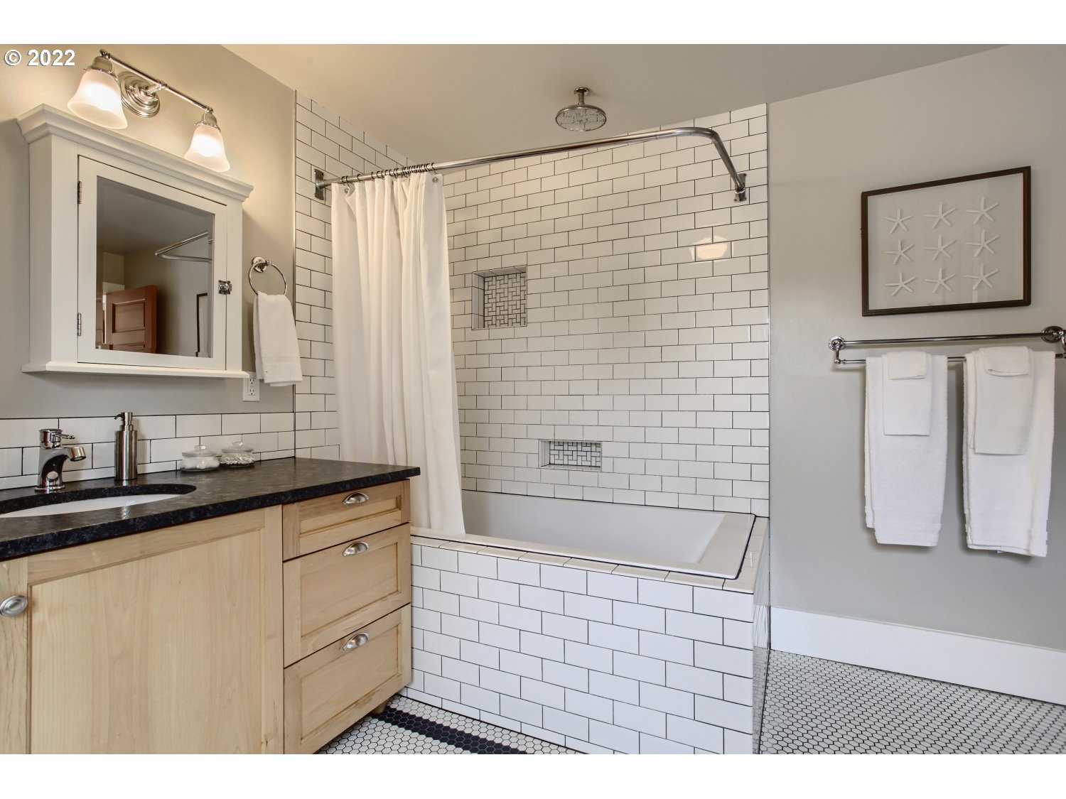 4347 Northeast Sumner Street Portland, OR 97218 - Photo 13 of 25 a bathroom with a sink a mirror and shower