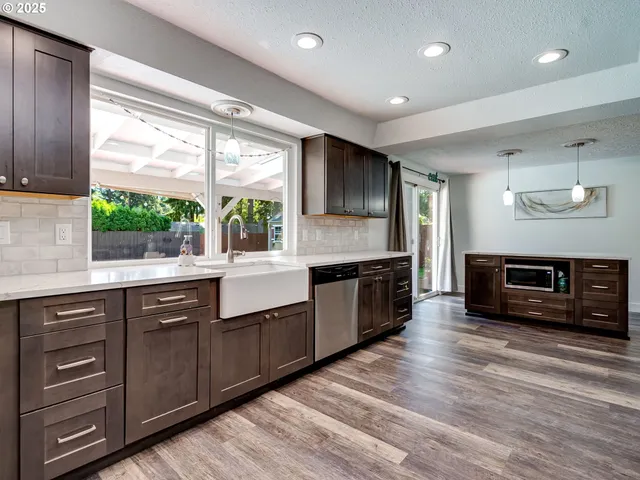 a large kitchen with stainless steel appliances granite countertop a stove and a sink