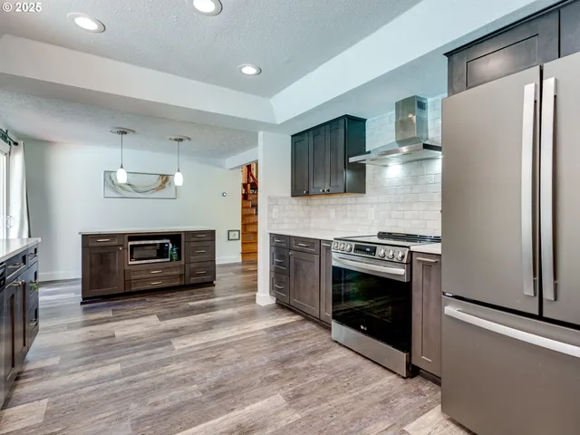 a kitchen with stainless steel appliances a stove a refrigerator and a microwave