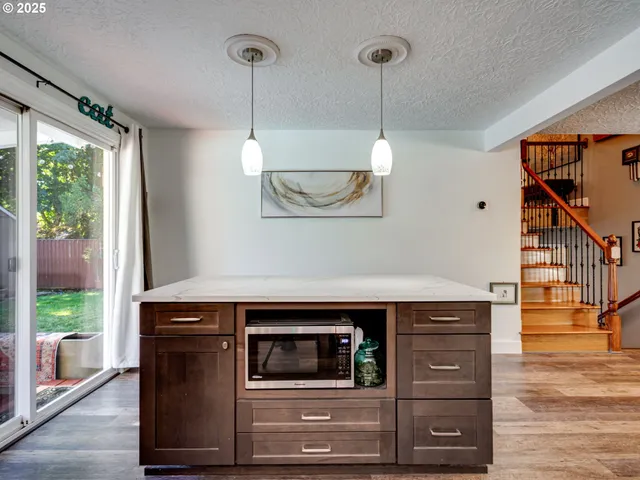 a kitchen with a stove and a wooden floor