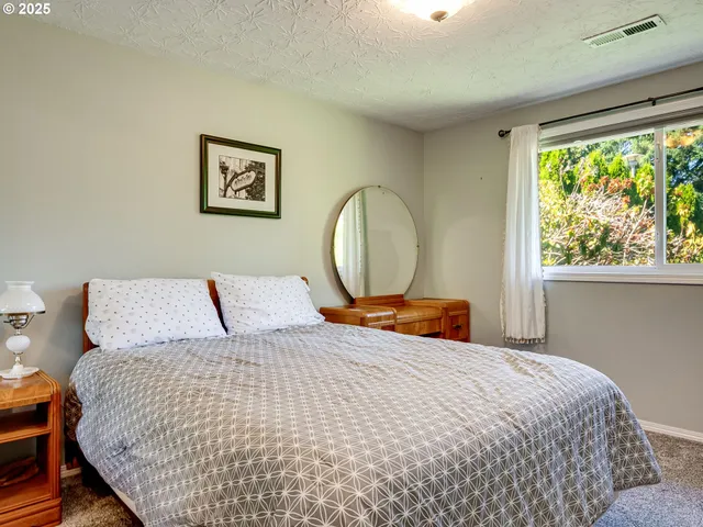 a bedroom with a large bed and a window