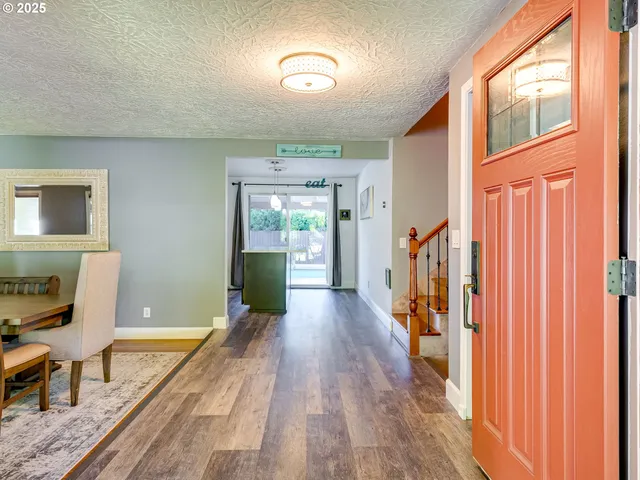 a view of a hallway with wooden floor and furniture