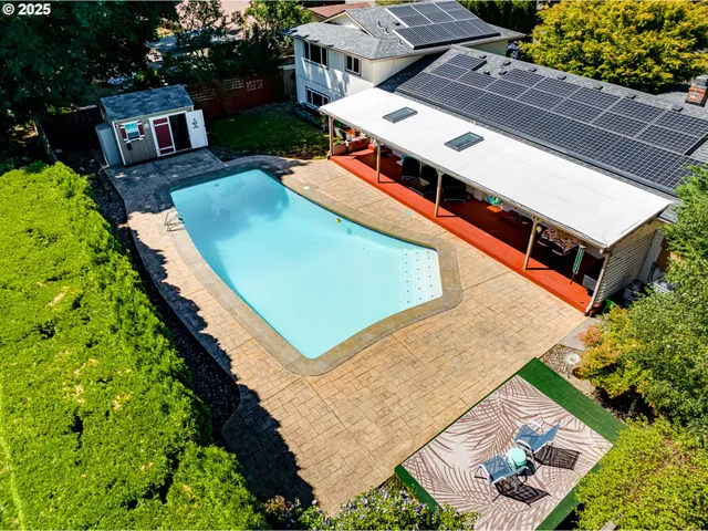 an aerial view of a house with a yard and greenery