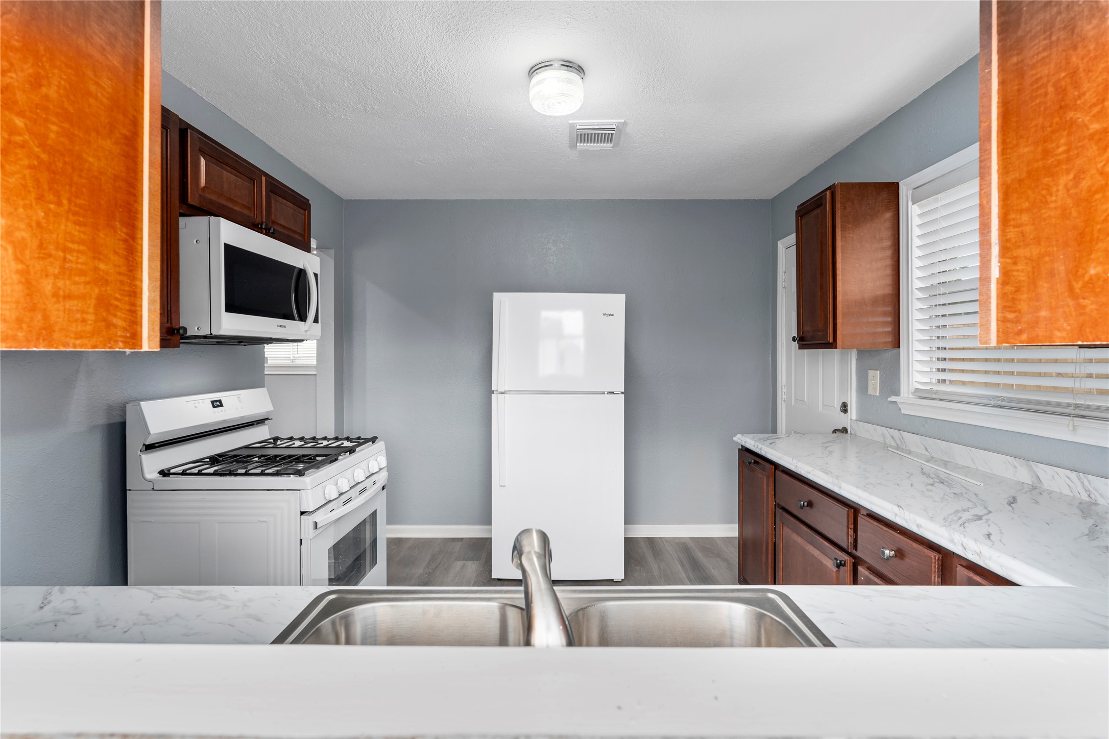 a kitchen with stainless steel appliances kitchen island a stove a sink and a microwave