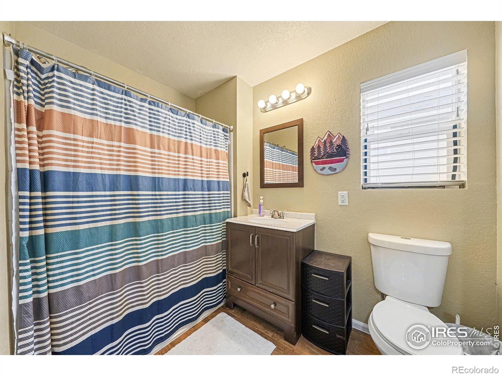 6815 Autumn Ridge Drive Fort Collins, CO 80525 - Photo 15 of 23 a bathroom with a sink a toilet and shower curtain