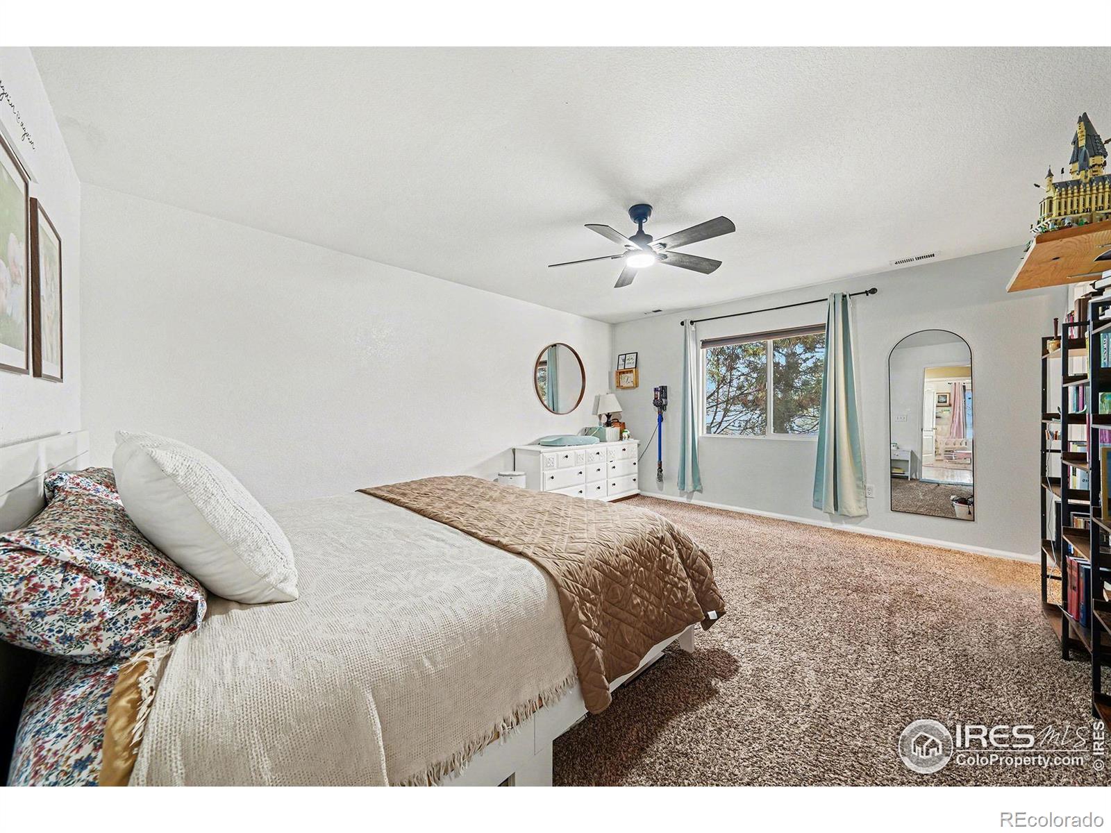 6815 Autumn Ridge Drive Fort Collins, CO 80525 - Photo 7 of 23 a bedroom with a bed and a chandelier