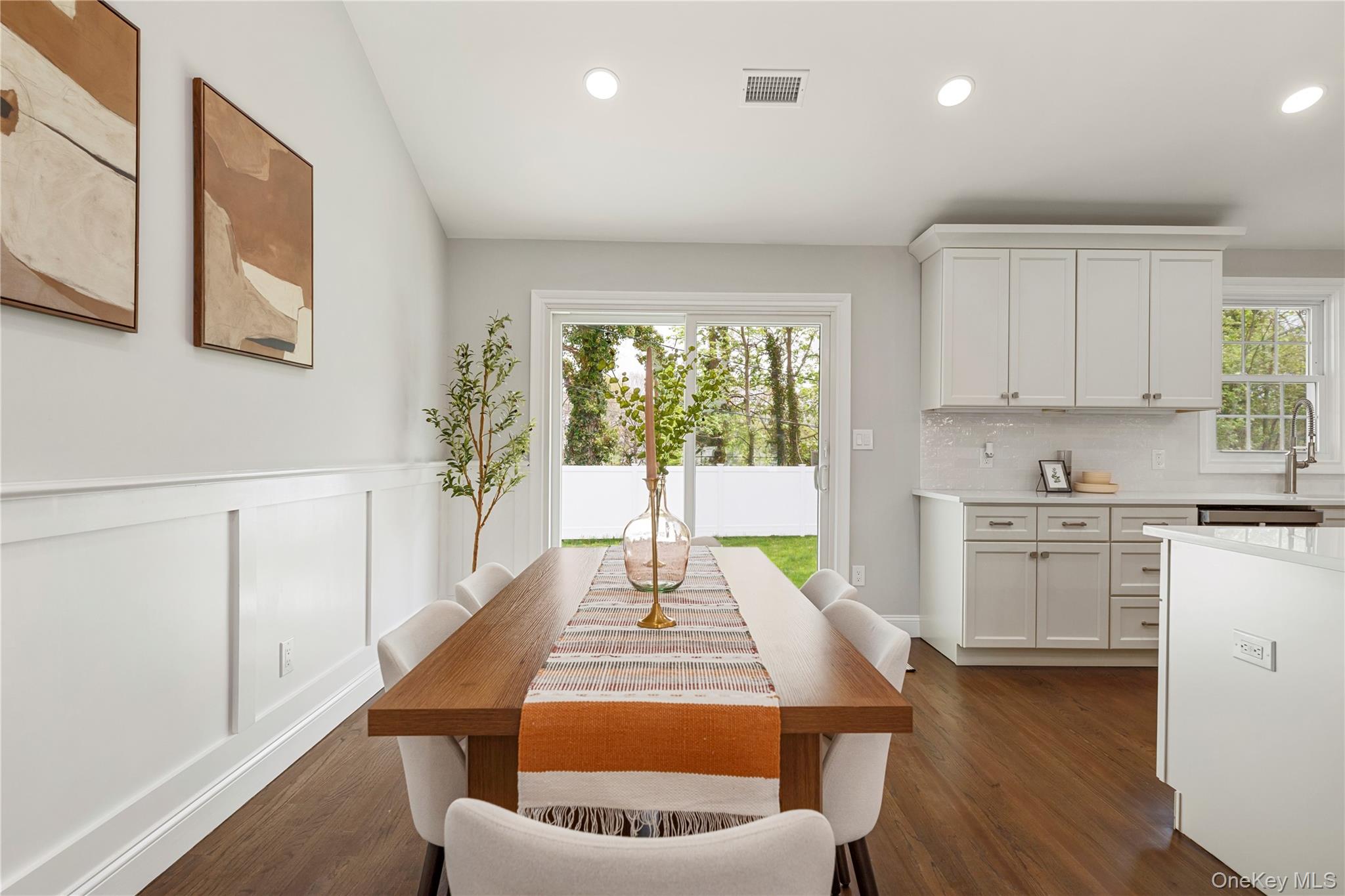 16 Eleanor Road Plainview, NY 11803 - Photo 12 of 28 Open-concept dining area featuring wood-finish flooring, recessed lighting, and wainscoting and access to back yard