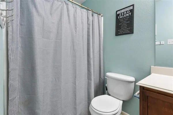 a white toilet sitting next to a shower curtain