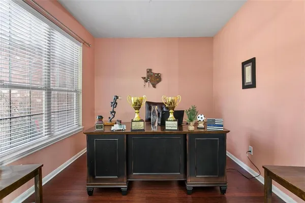 a view of a workspace with furniture and a window