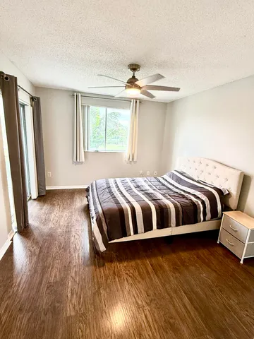 a bedroom with a bed and a ceiling fan