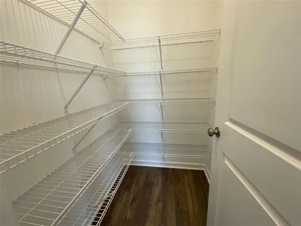 a living room with furniture kitchen view and a wooden floor