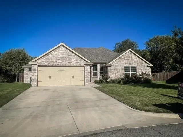 a view of a house with a yard and large tree