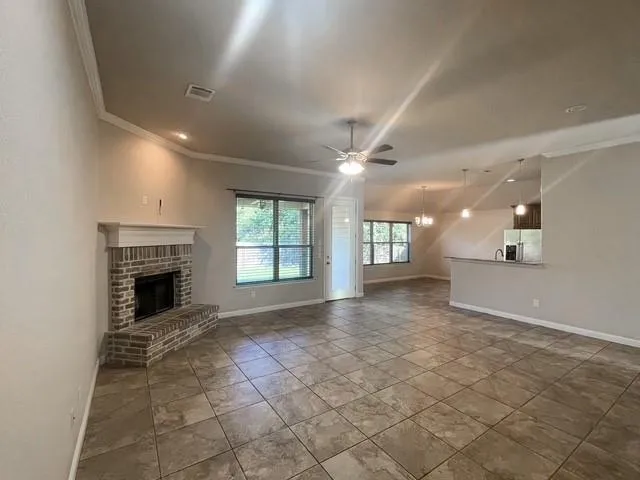 an empty room with windows and fireplace