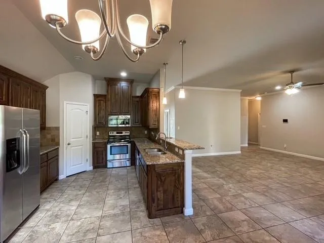 a kitchen with stainless steel appliances granite countertop a stove cabinets and refrigerator