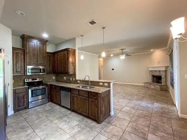 a kitchen with stainless steel appliances granite countertop a stove a sink a counter top space and cabinets
