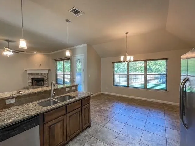 a large kitchen with granite countertop a sink and a wooden floor