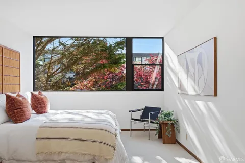 a bedroom with a bed and a painting on the wall