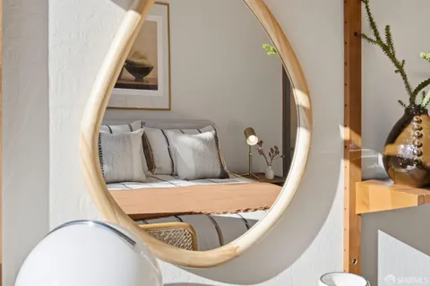 a bedroom with a bed and a dresser next to a window