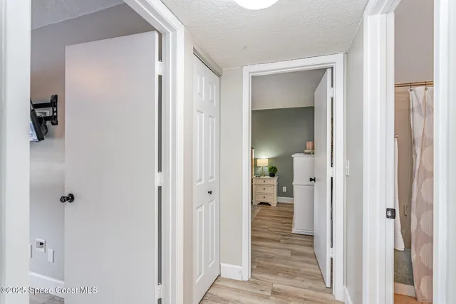 a view of a hallway with wooden floor and closet area