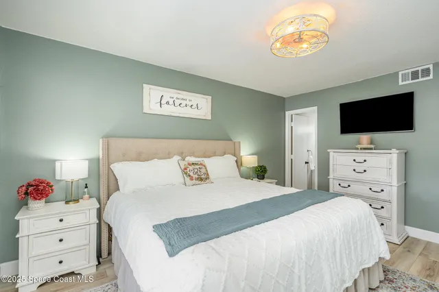 a bedroom with a bed and a flat screen tv