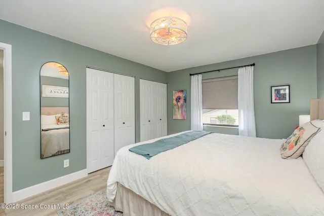 a bedroom with a bed and a chandelier