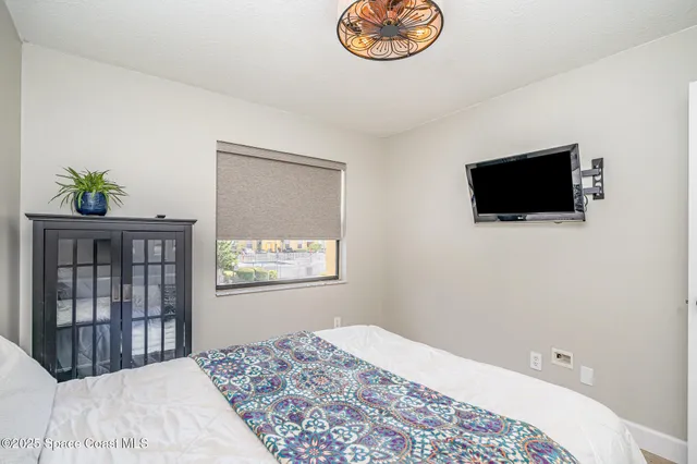 a bedroom with a bed and a flat screen tv