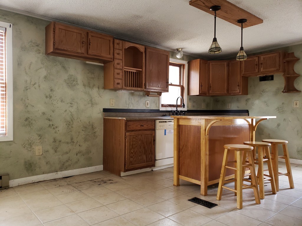 60 Haggerty Road Charlton, MA 01507 - Photo 8 of 28 a kitchen with granite countertop a sink and a refrigerator