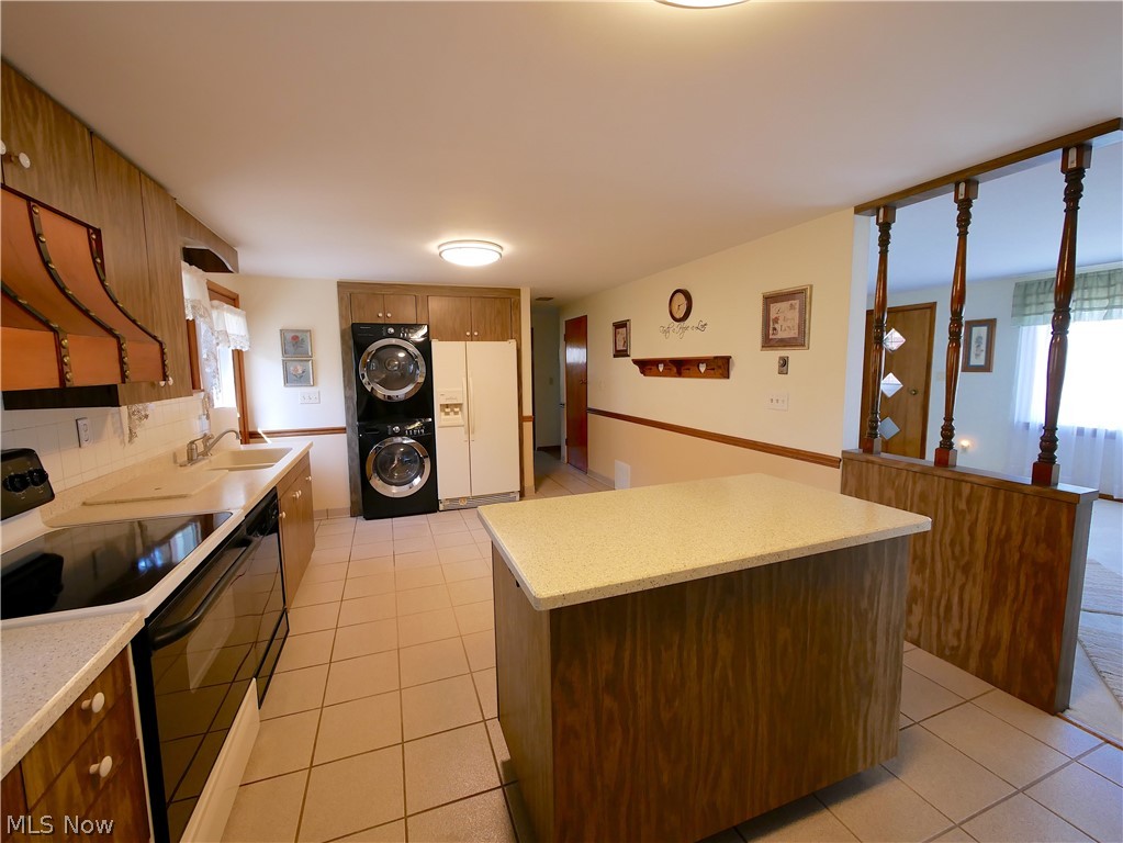 57500 Hospital Road Bellaire, OH 43906 - Photo 19 of 22 Kitchen featuring backsplash, stacked washer / dryer, white appliances, and a wealth of natural light