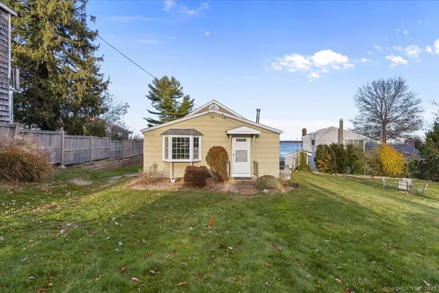 a view of a house with backyard and trees