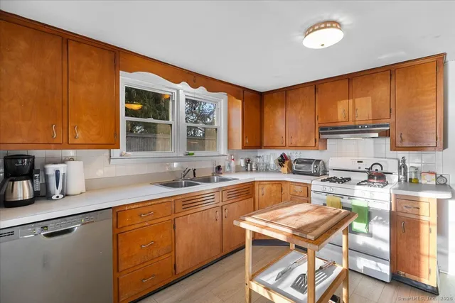 a kitchen with a sink stove top oven and cabinets