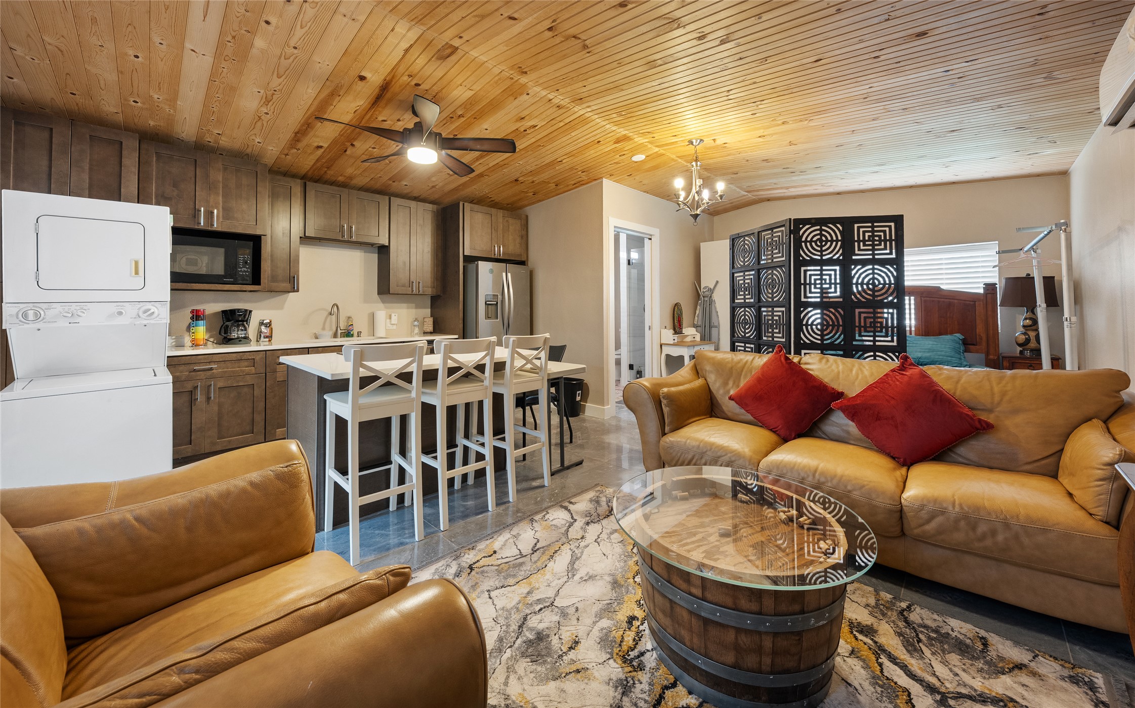 301 Oak Ridge Road Georgetown, TX 78628 - Photo 26 of 34 Open-concept living space featuring a wood-panel ceiling, full kitchen with wood-finish cabinetry, stainless steel appliances, and a stacked washer/dryer unit