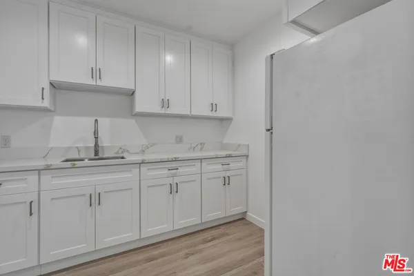 a kitchen with granite countertop white cabinets and sink