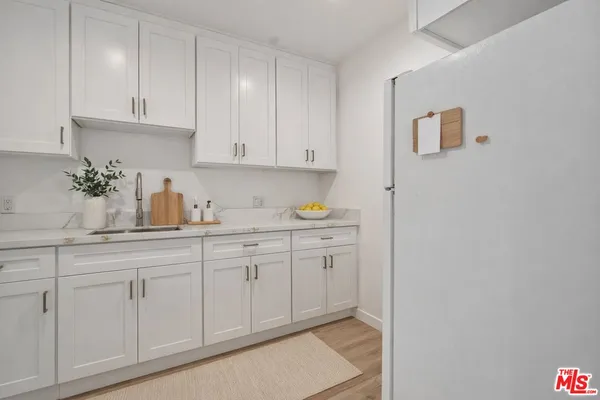 a kitchen with granite countertop white cabinets and sink