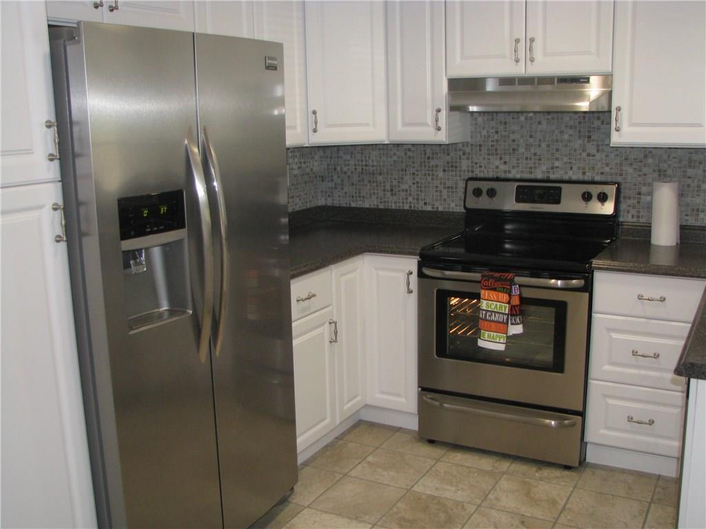 1101 Isabella Road Connellsville, PA 15425 - Photo 3 of 25 Newly remodeled kitchen offers white cabinets, tile floor and backsplash as well as stainless steel appliances.