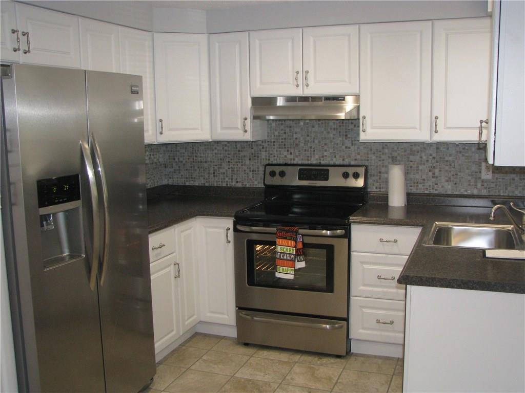1101 Isabella Road Connellsville, PA 15425 - Photo 4 of 25 A new stainless steel refrigerator, stove and dishwasher and included in this charming kitchen that features white cabinetry, and ceramic tile backsplash and flooring.