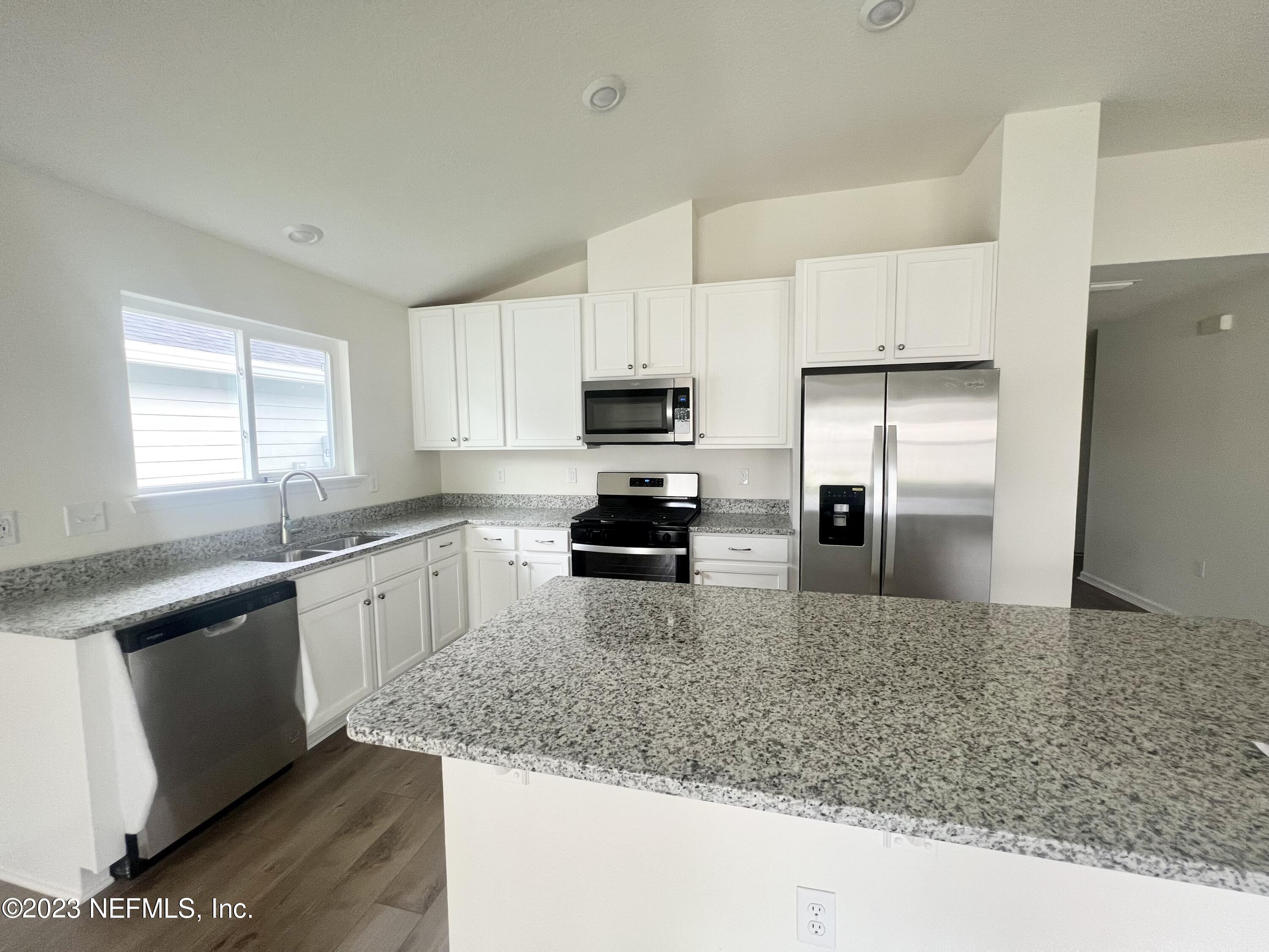 7954 Rippa Valley Way Jacksonville, FL 32222 - Photo 4 of 9 a kitchen with granite countertop a refrigerator and a sink